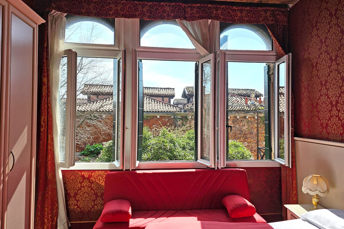 A room with a bed, a window, and a lamp.