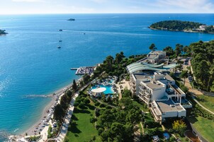 Vista aerea di un resort costiero con piscina, spiaggia e vista sull'oceano.