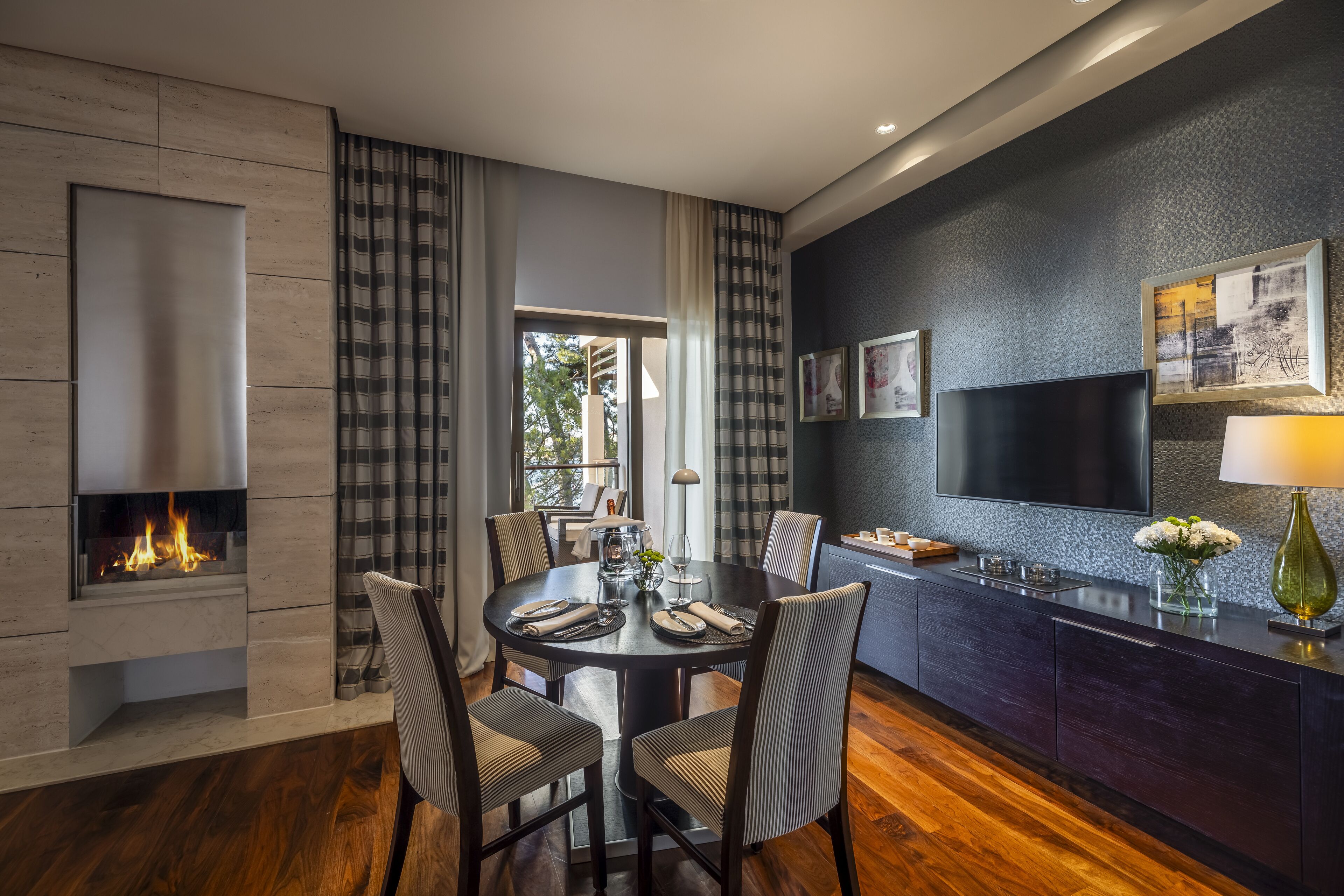 A modern dining area with a fireplace, a round table, and chairs.