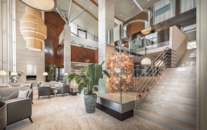 A spacious lobby with a modern staircase, seating area, and a large decorative plant. - Monte Mulini Adults Exclusive Hotel by Maistra Collection (Rovinj)