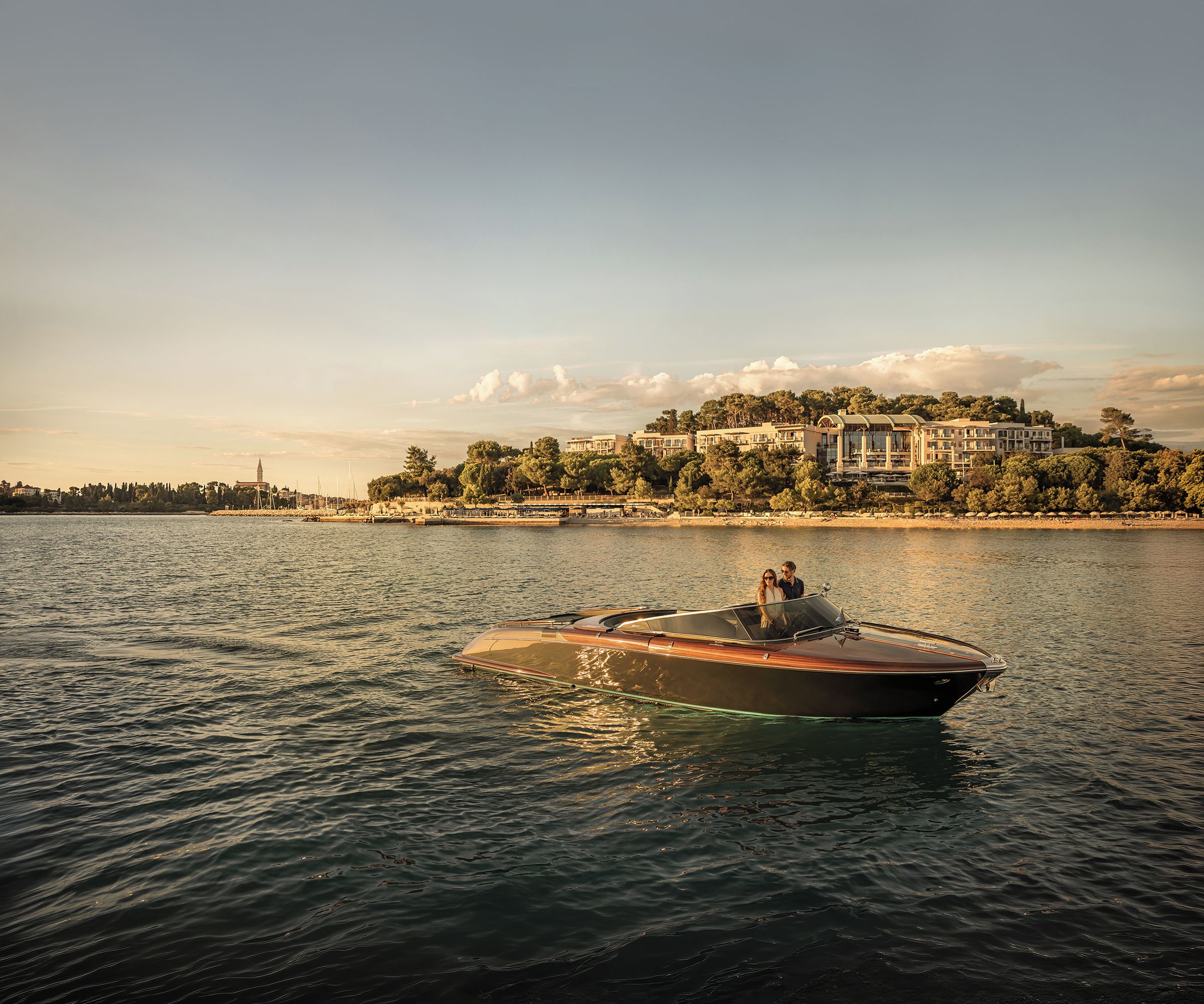 A boat on calm water with a large building in the background.