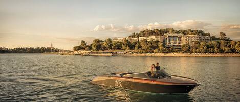 A boat on calm water with a large building in the background.