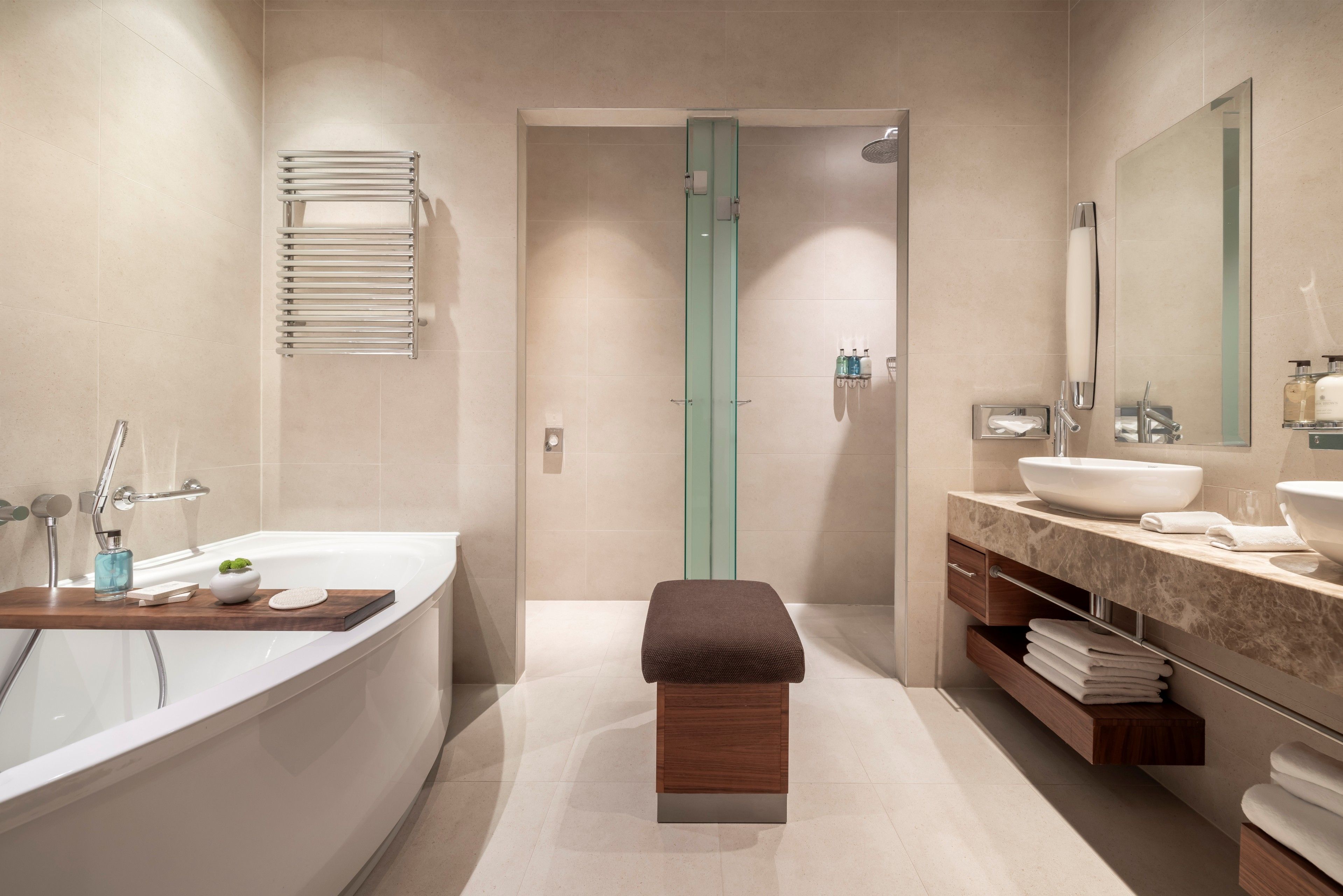 Un baño moderno con bañera, ducha y tocador con lavamanos y espejo.