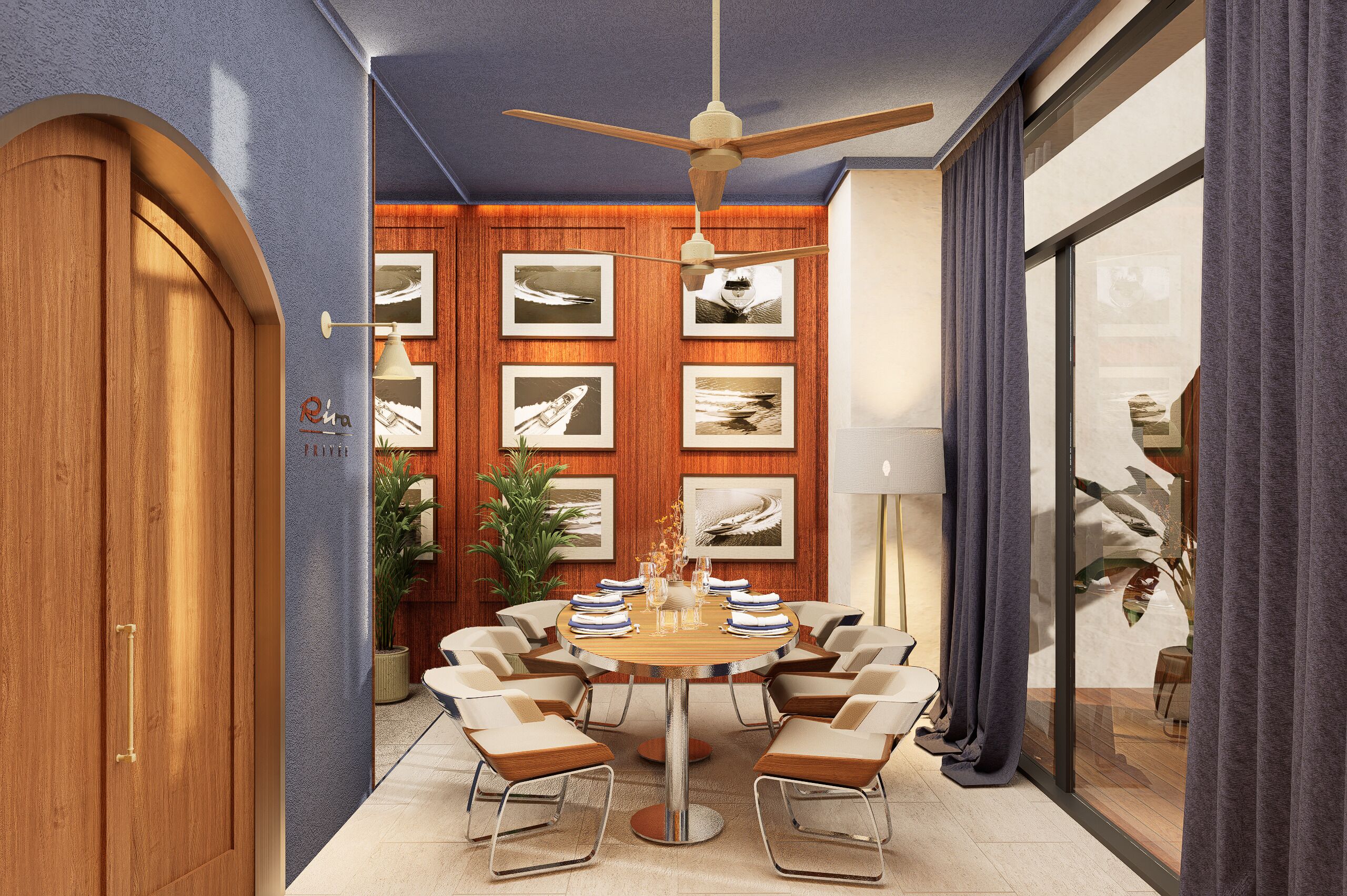 A conference room with a round table, chairs, a ceiling fan, framed pictures on the wall, and a large window with curtains.