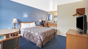 A hotel room with a bed, bedside tables, a desk, a chair, a television, and a mirror. - Days Inn by Wyndham Seattle North of Downtown (Seattle)