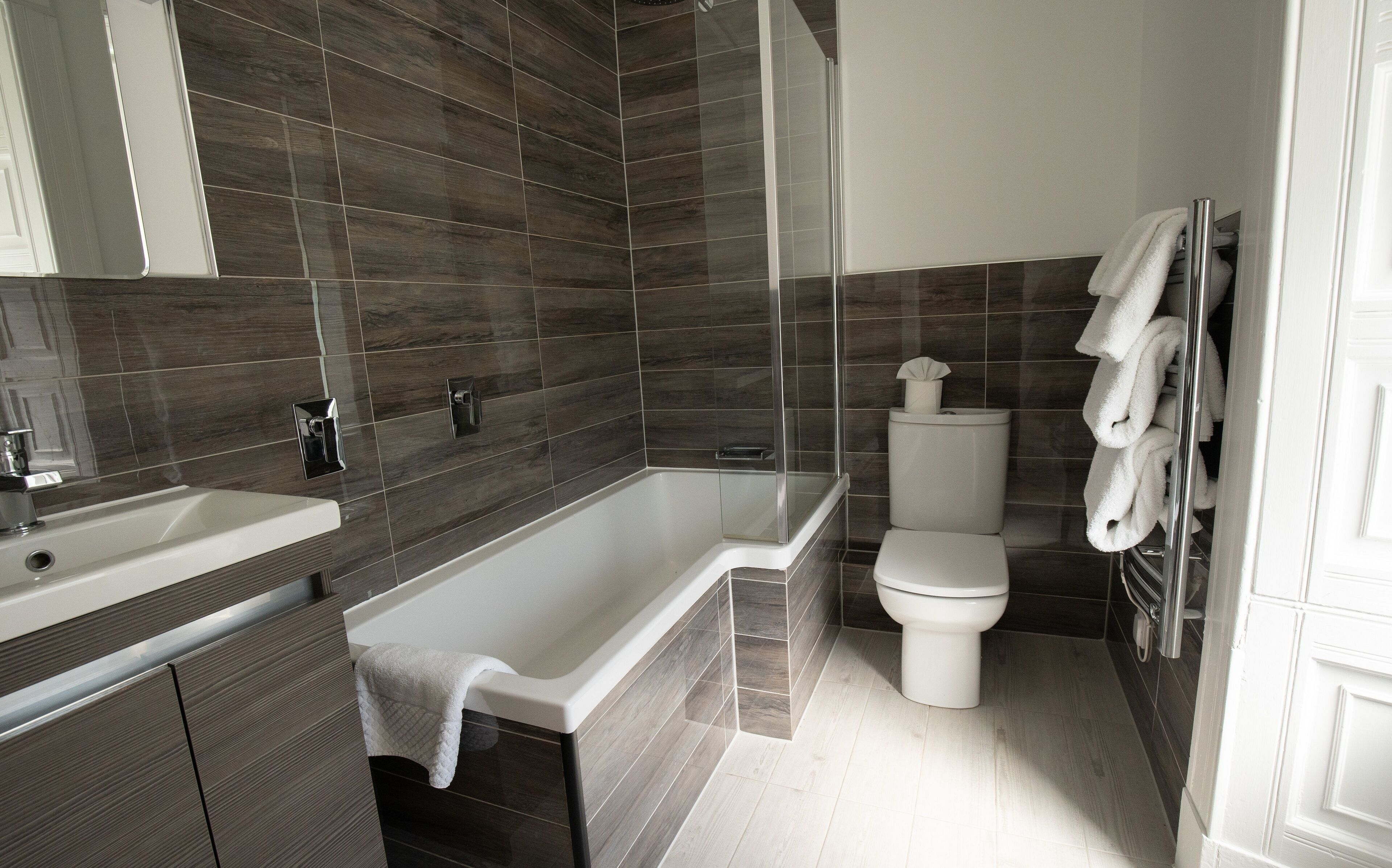 A modern bathroom with a bathtub, toilet, and sink.