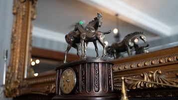 Eine Uhr mit römischen Ziffern und einer Pferdefigur obenauf.