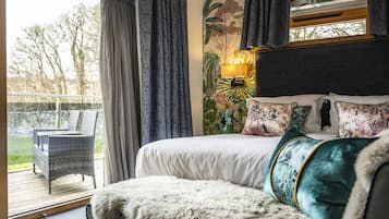 A bedroom with a large bed, a chair, and a view of the outdoors.