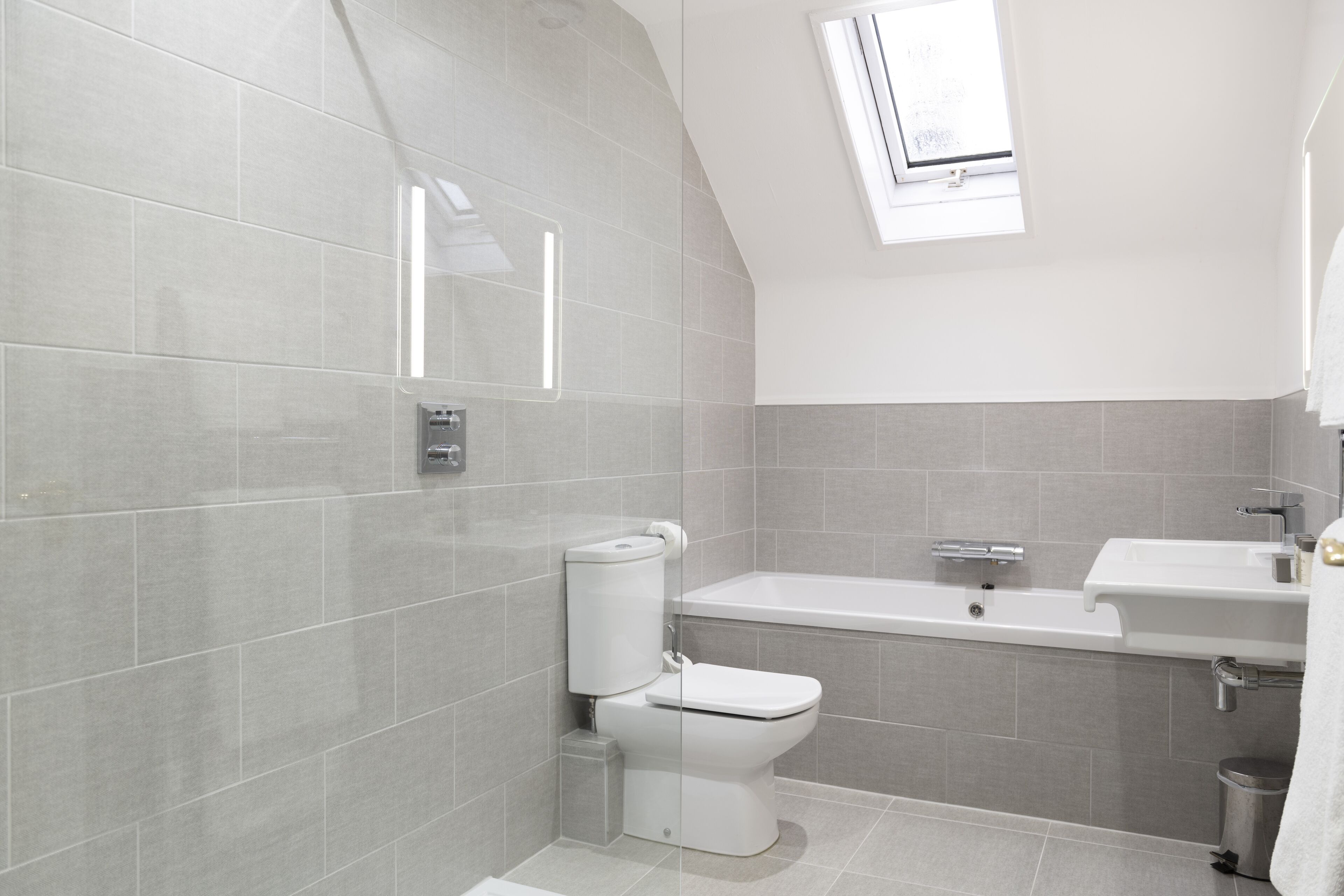 Un baño moderno con inodoro, bañera y lavamanos.