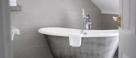 A modern bathroom with a freestanding bathtub, a toilet, and a sink.
