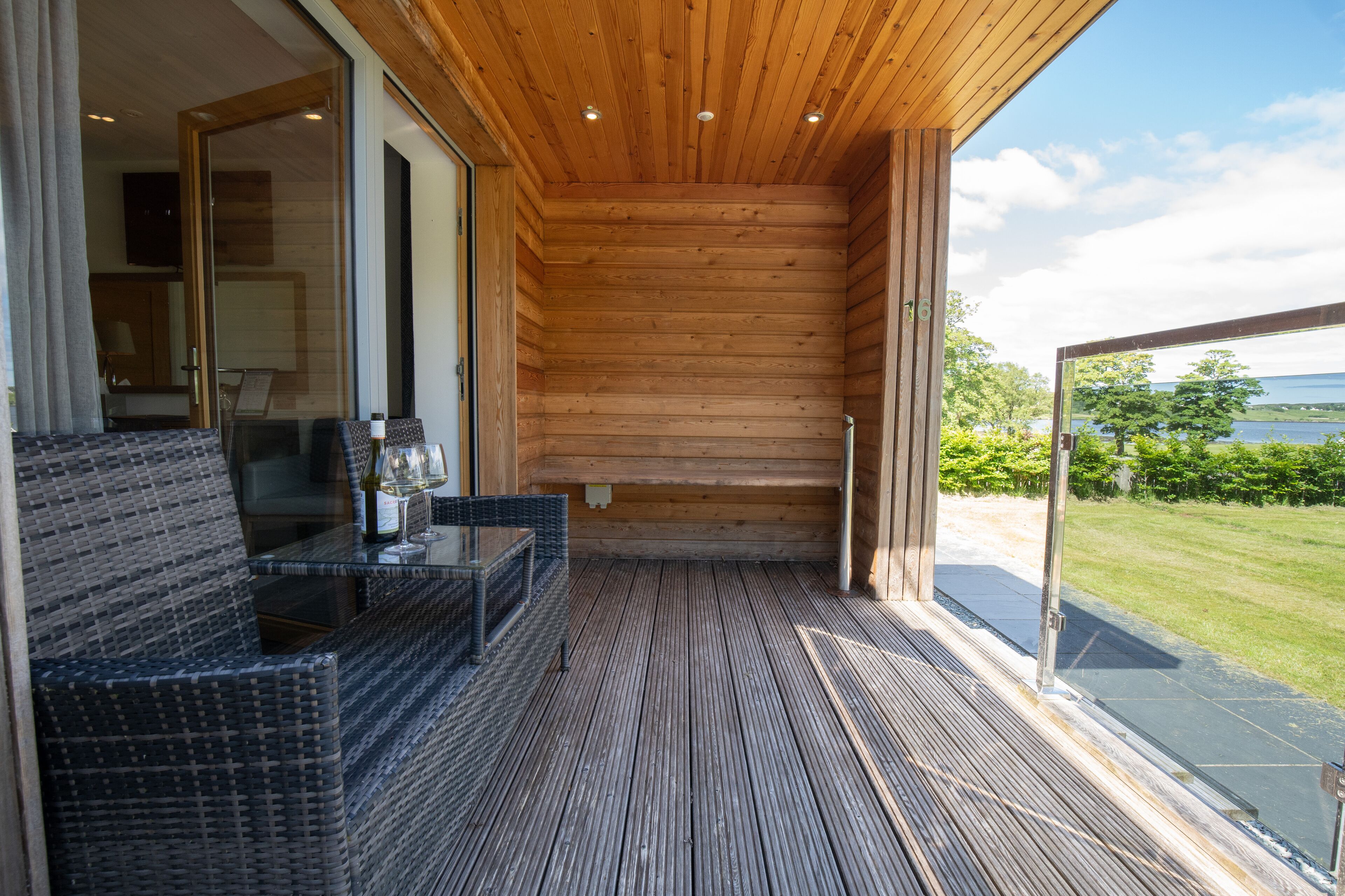 Ein Zimmer mit Holzwänden und einer Glastür, die auf einen Balkon führt.
