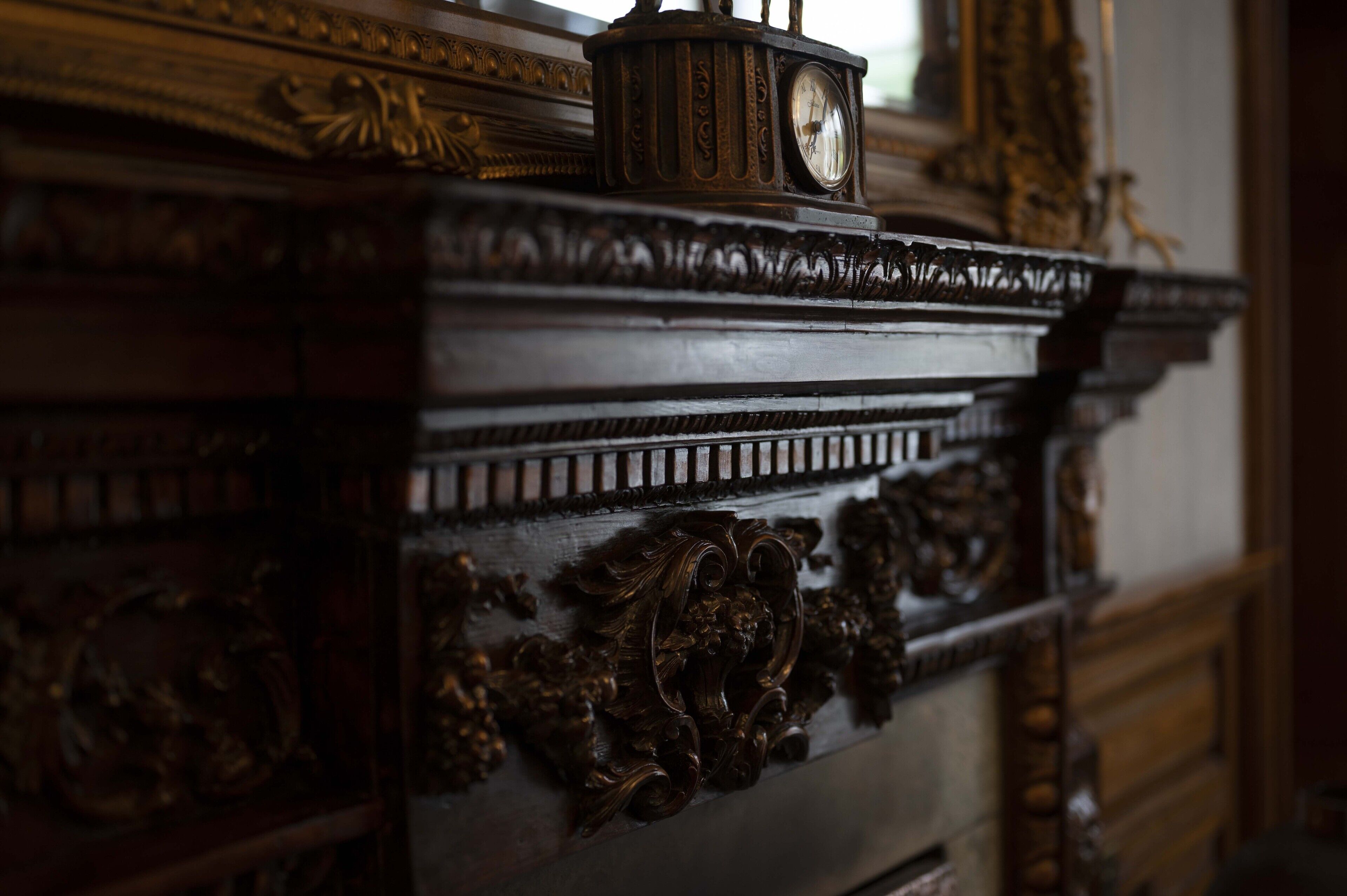 Un mueble de madera detallado con intrincados adornos y un reloj en la parte superior.