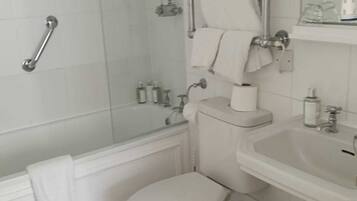 A modern bathroom with a glass-enclosed shower, a white toilet, a sink, and a trash can.