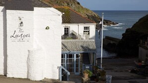 A coastal building named 'The Lugger' with a balcony, a staircase, and a view of the sea. - The Lugger Hotel (Truro)