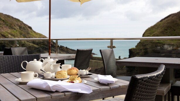 A table set with tea and scones, overlooking a coastal view. - The Lugger Hotel (Truro)