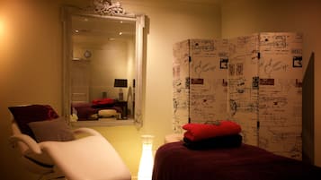 Cozy retreat with a large mirror, bedside table, and comfortable chair.