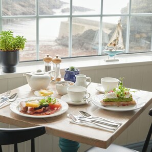 A breakfast table set with plates of food, cups, and utensils. - The Lugger Hotel (Truro)