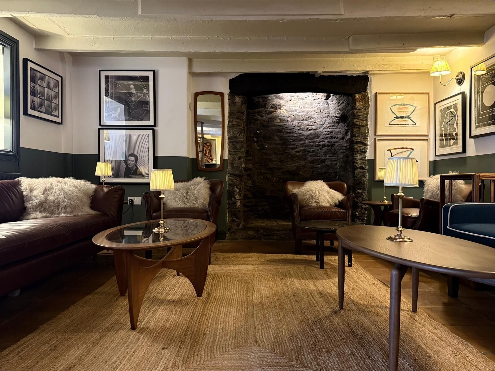Ett mysigt loungeområde med en vägg av sten, lädersoffor och ett soffbord.
