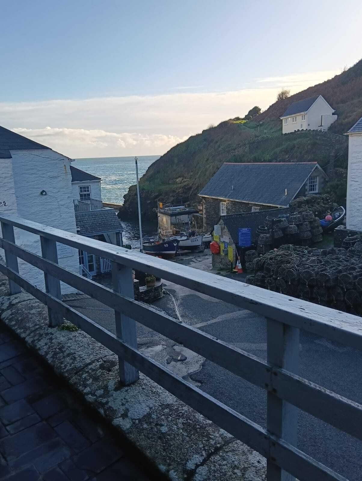 Une ville côtière avec des bâtiments situés près de la mer, un pont et un paysage rocheux.