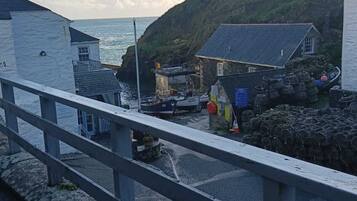 Une ville côtière avec des bâtiments situés près de la mer, un pont et un paysage rocheux.
