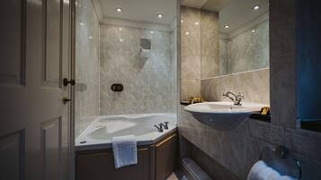 A modern bathroom with a freestanding bathtub, a sink, and a shower.