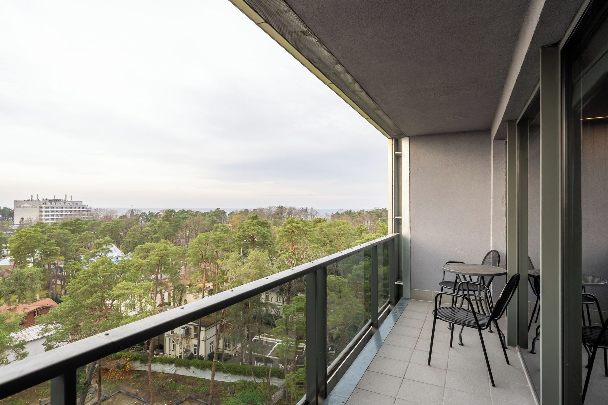A balcony with a view of a cityscape and trees.