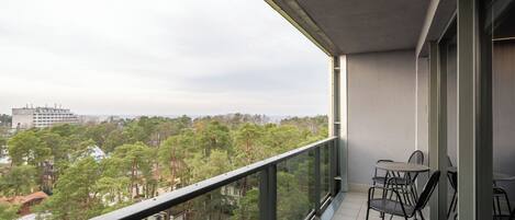 A balcony with a view of a cityscape and trees.