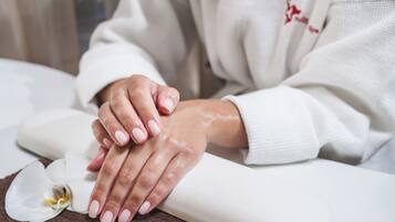 A close-up of hands resting on a towel, with a white flower nearby.