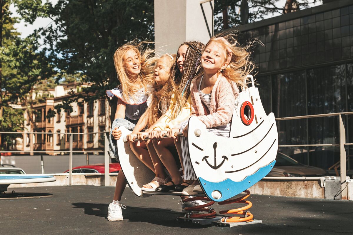 A group of children playing on a swing set.