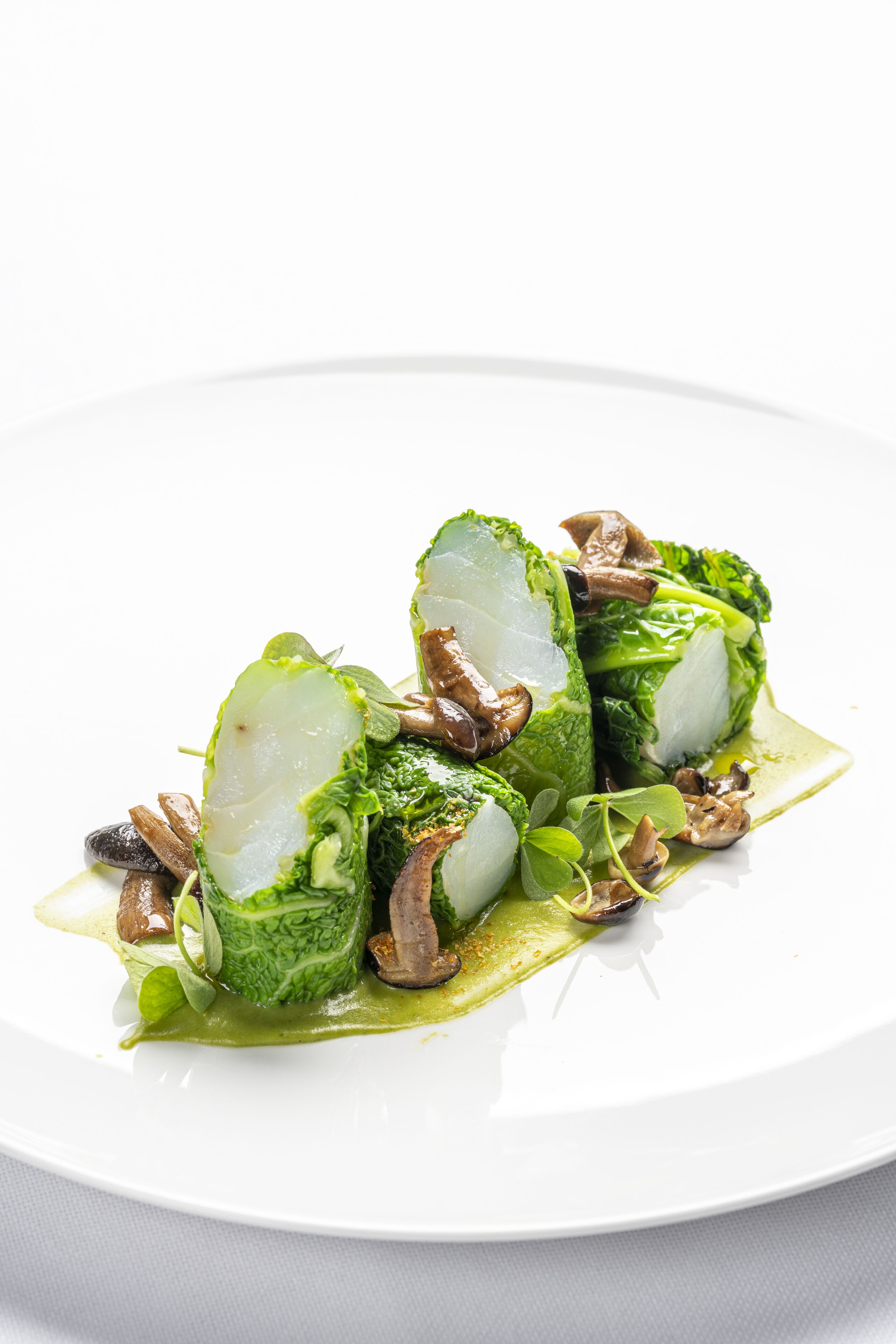 Une assiette blanche contenant un plat de légumes verts et de champignons.
