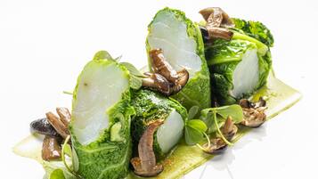 Une assiette blanche contenant un plat de légumes verts et de champignons.