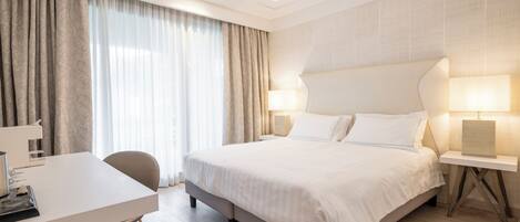 Una habitación de hotel con cama, mesitas de noche, escritorio y silla.