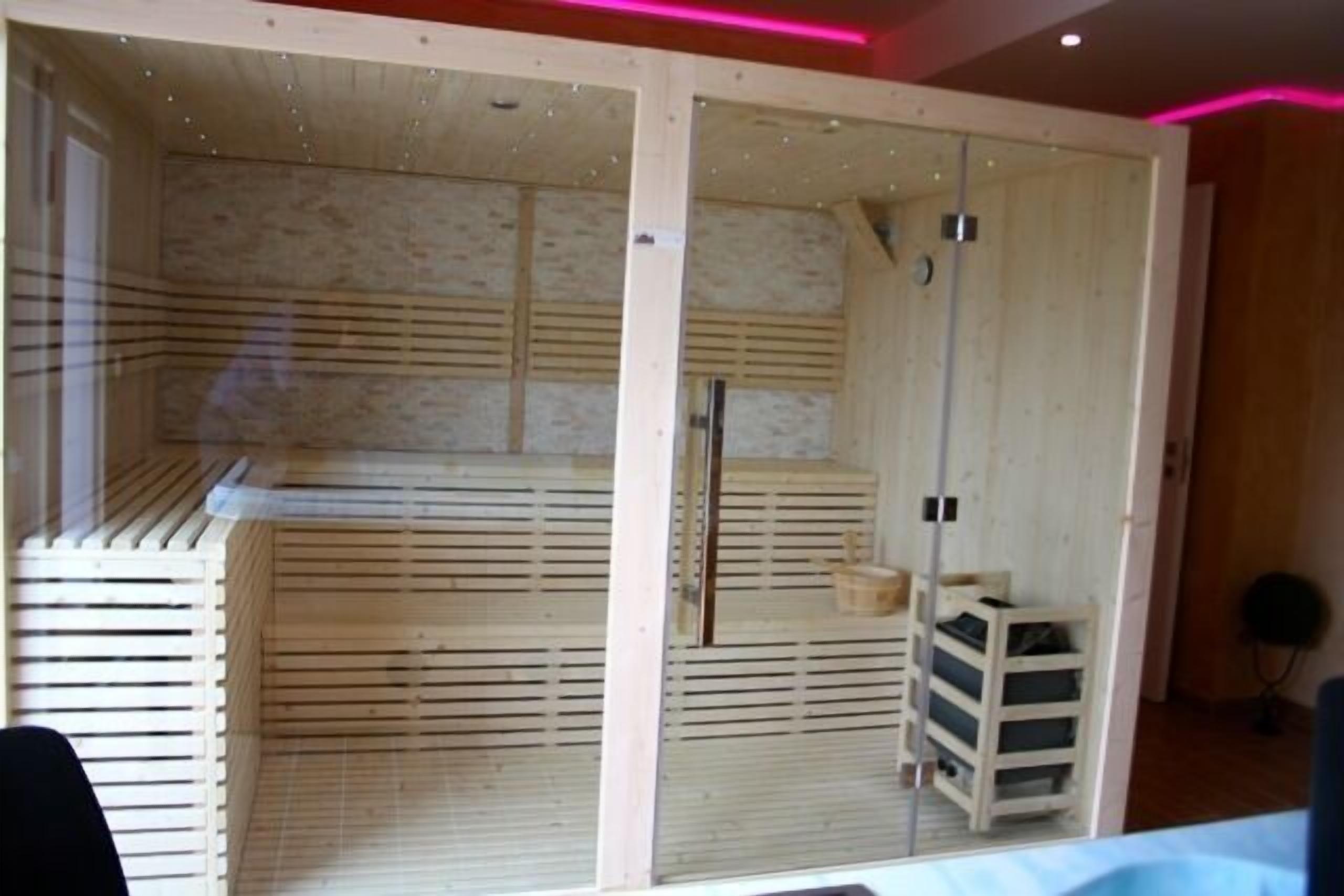 A room with a wooden slatted wall, a small wooden cabinet, and a door.