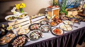 A buffet table with various dishes and a decorative rabbit figurine. - Hotel Baltvilla (Garkalnes novads)