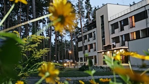 A modern building with multiple floors, surrounded by a forested area. - Hotel Baltvilla (Garkalnes novads)