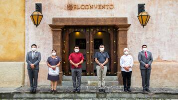 Un grupo de personas de pie frente a un edificio con un letrero que dice 'EL CONVENTO'.