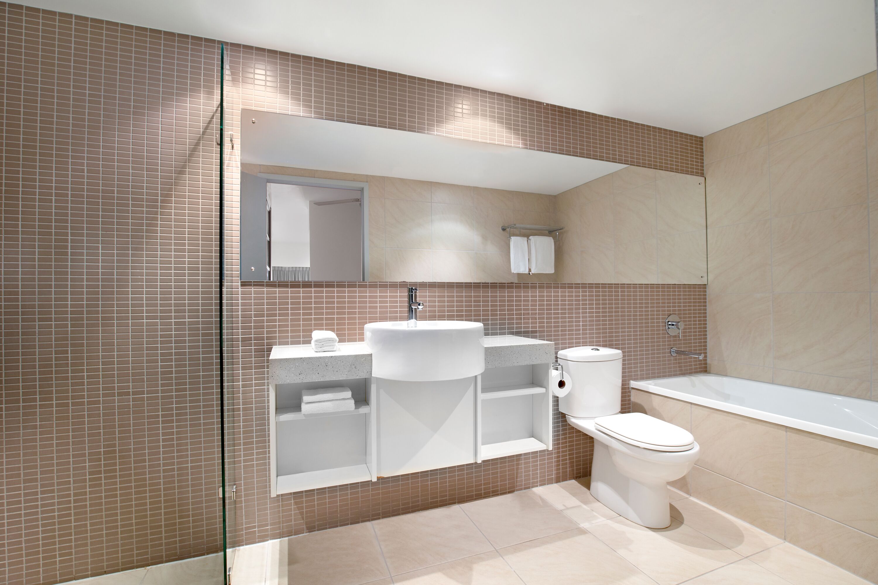 Un baño moderno con una bañera grande, un lavabo y un inodoro.