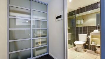 A bathroom with a toilet, a sink, and a mirror.
