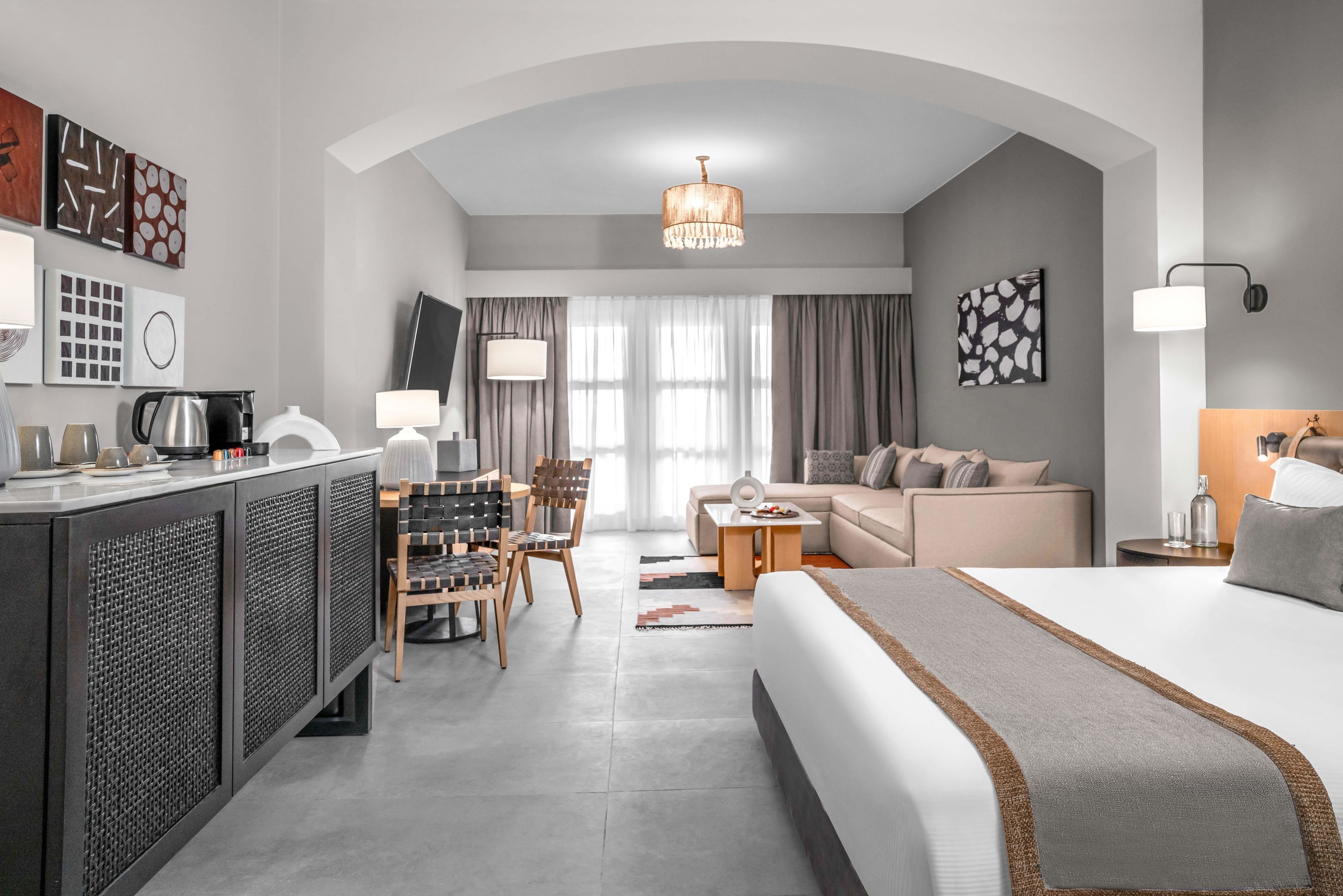 Une chambre d’hôtel moderne équipée d’un grand lit, d’un bureau, d’un canapé et d’une télévision.