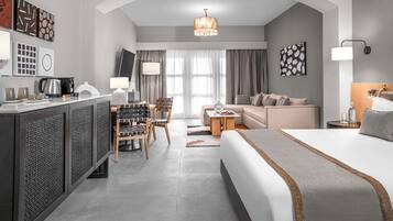Une chambre d’hôtel moderne équipée d’un grand lit, d’un bureau, d’un canapé et d’une télévision.