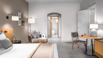 Une chambre d’hôtel moderne équipée d’un lit, d’une table de chevet, d’une lampe, d’une chaise et d’une petite table avec une lampe.