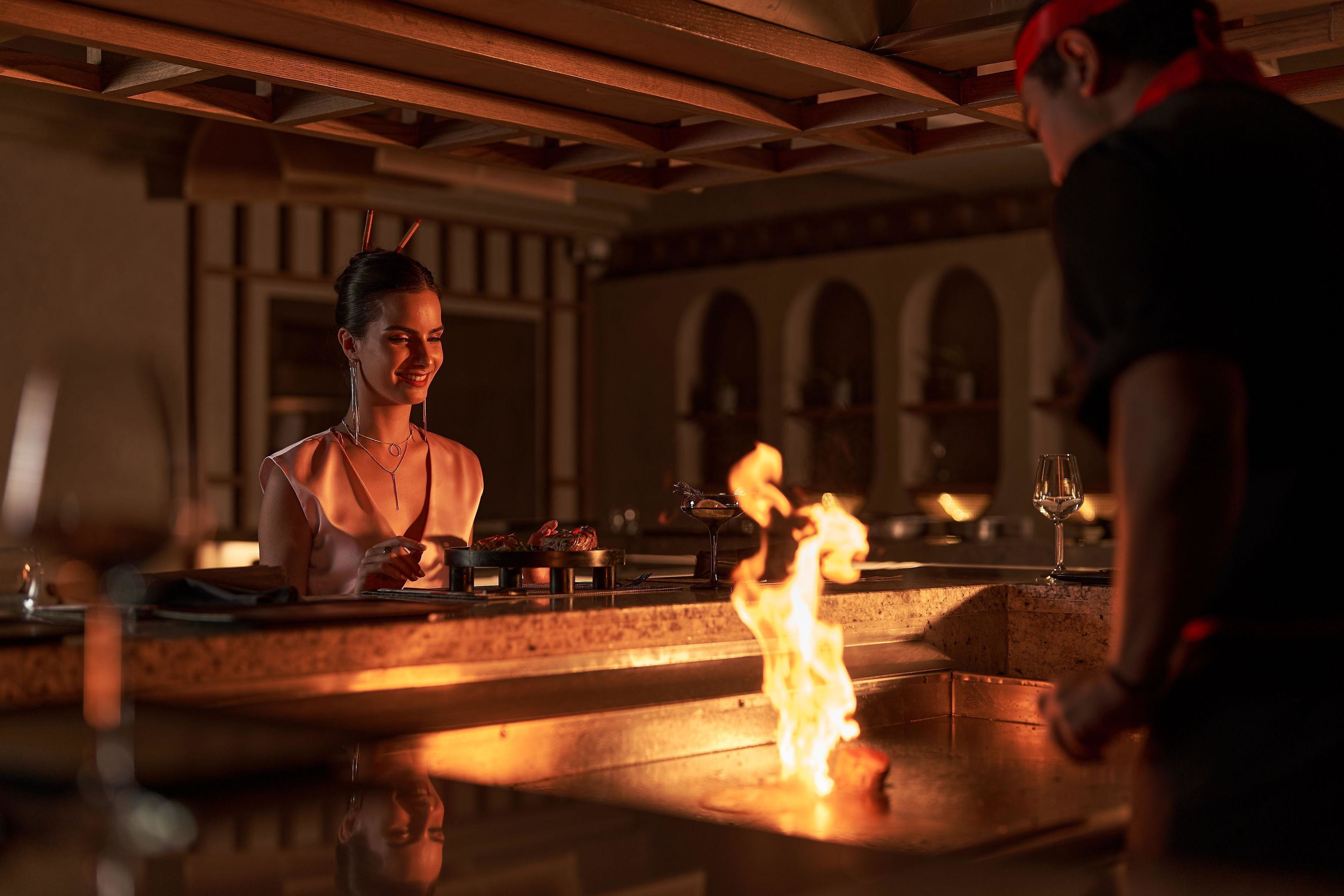Zona de bar con chimenea, barra y una persona de pie.