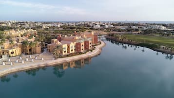 Um resort à beira-mar com marina, palmeiras e arquitetura em estilo mediterrâneo.