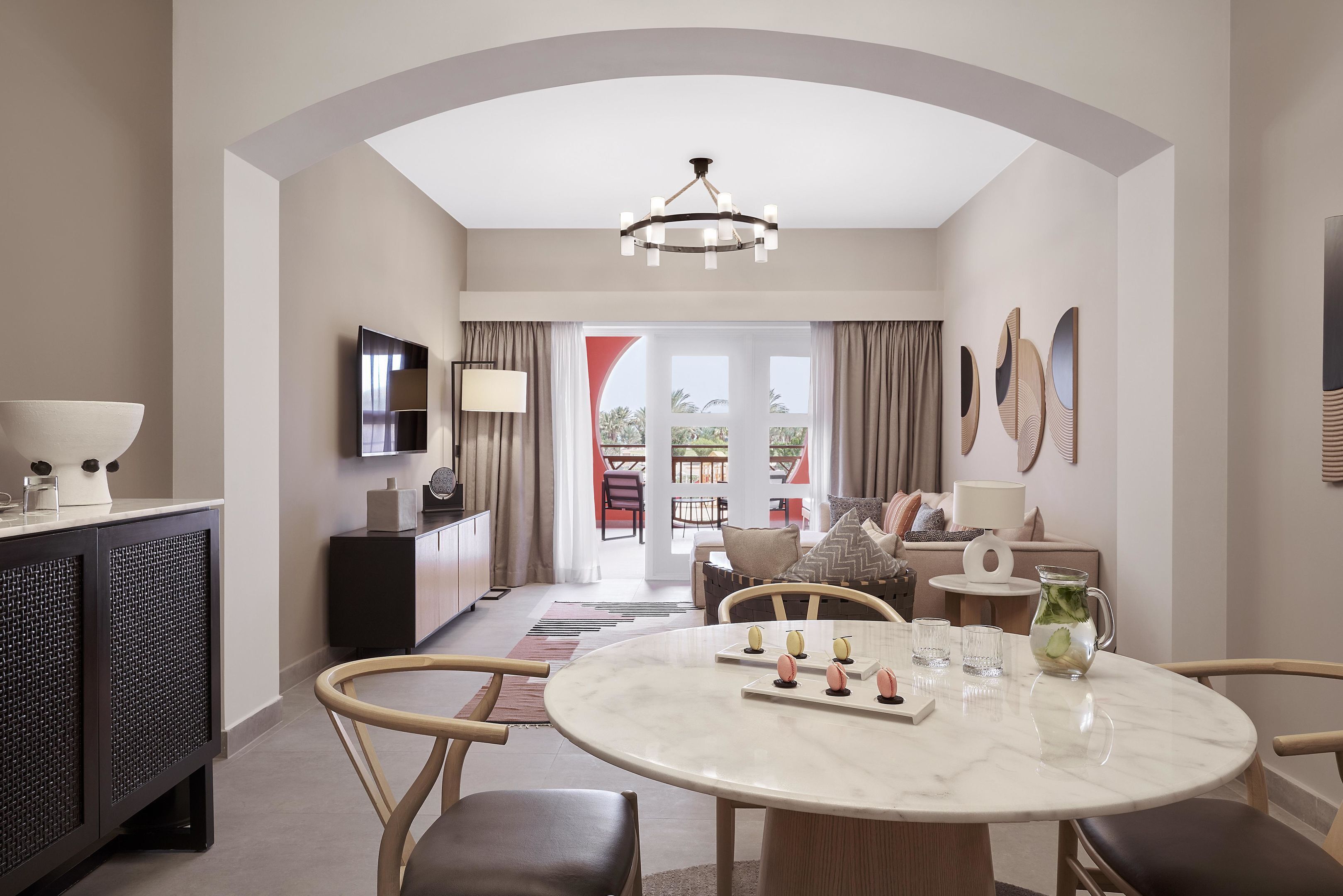 Een moderne hotelkamer met een zithoek, een televisie en uitzicht op de omgeving.