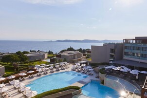 Una piscina techada, camas de piscina con cargo, sombrillas