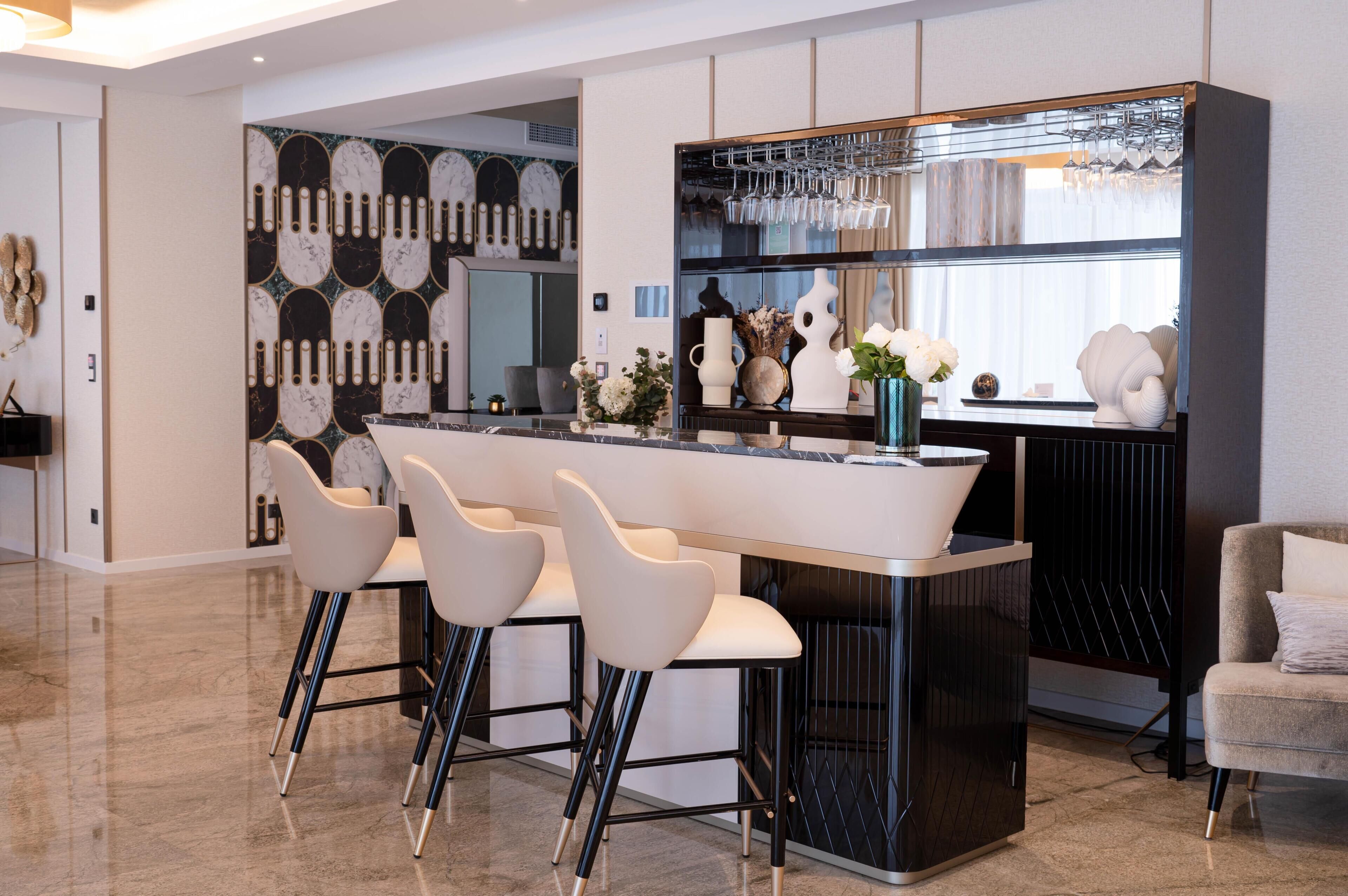 Een moderne keuken met een centraal eiland, barstoelen en een zithoek met een bank.