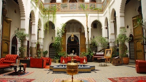 A spacious interior with a central fountain, red sofas, and ornate decor.