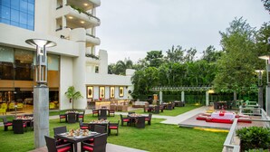 A hotel courtyard with outdoor seating, a bar, and a pool area. - Ellaa Hotel Gachibowli (Hyderabad)