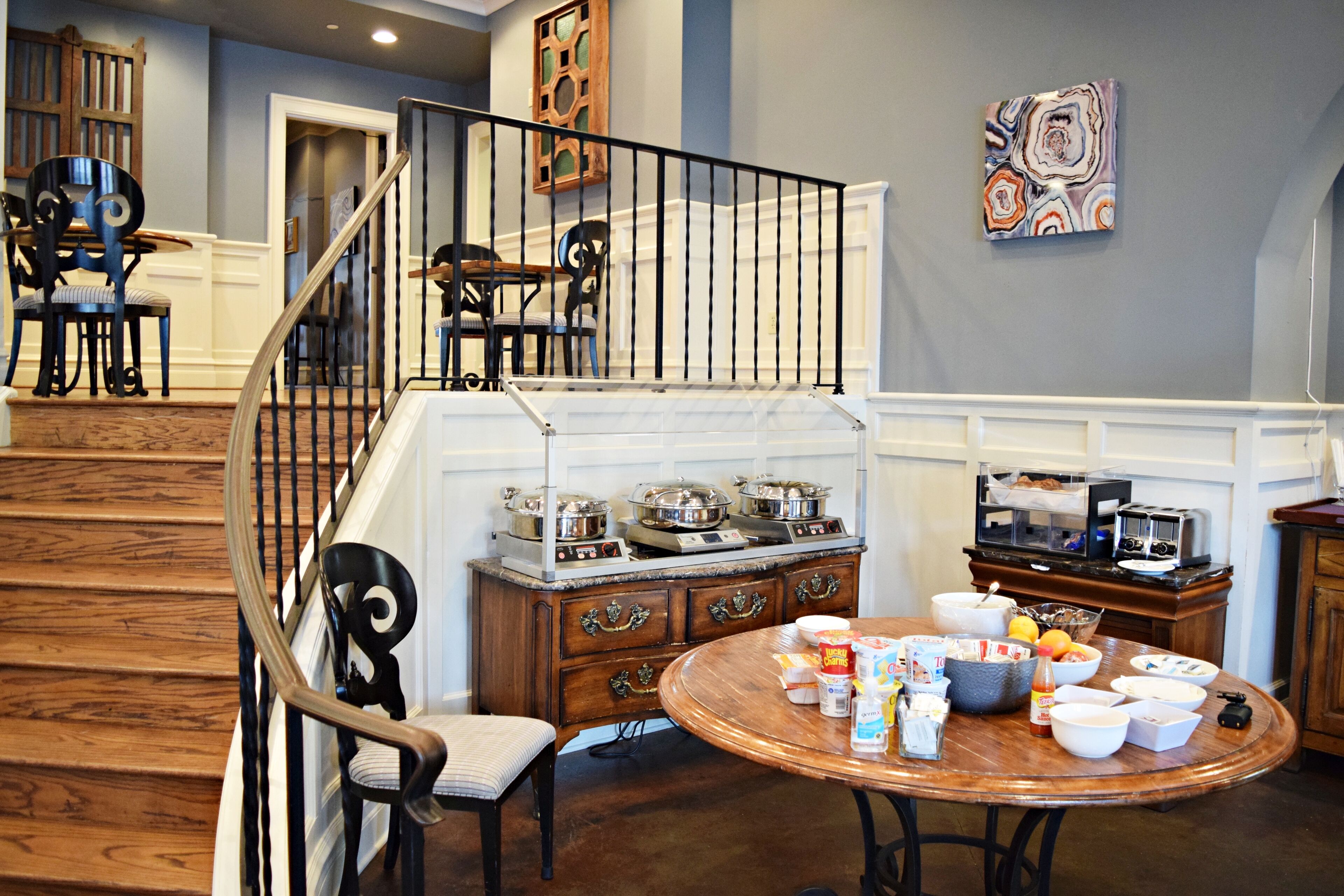 Un espace repas avec une table ronde, des chaises et un buffet.