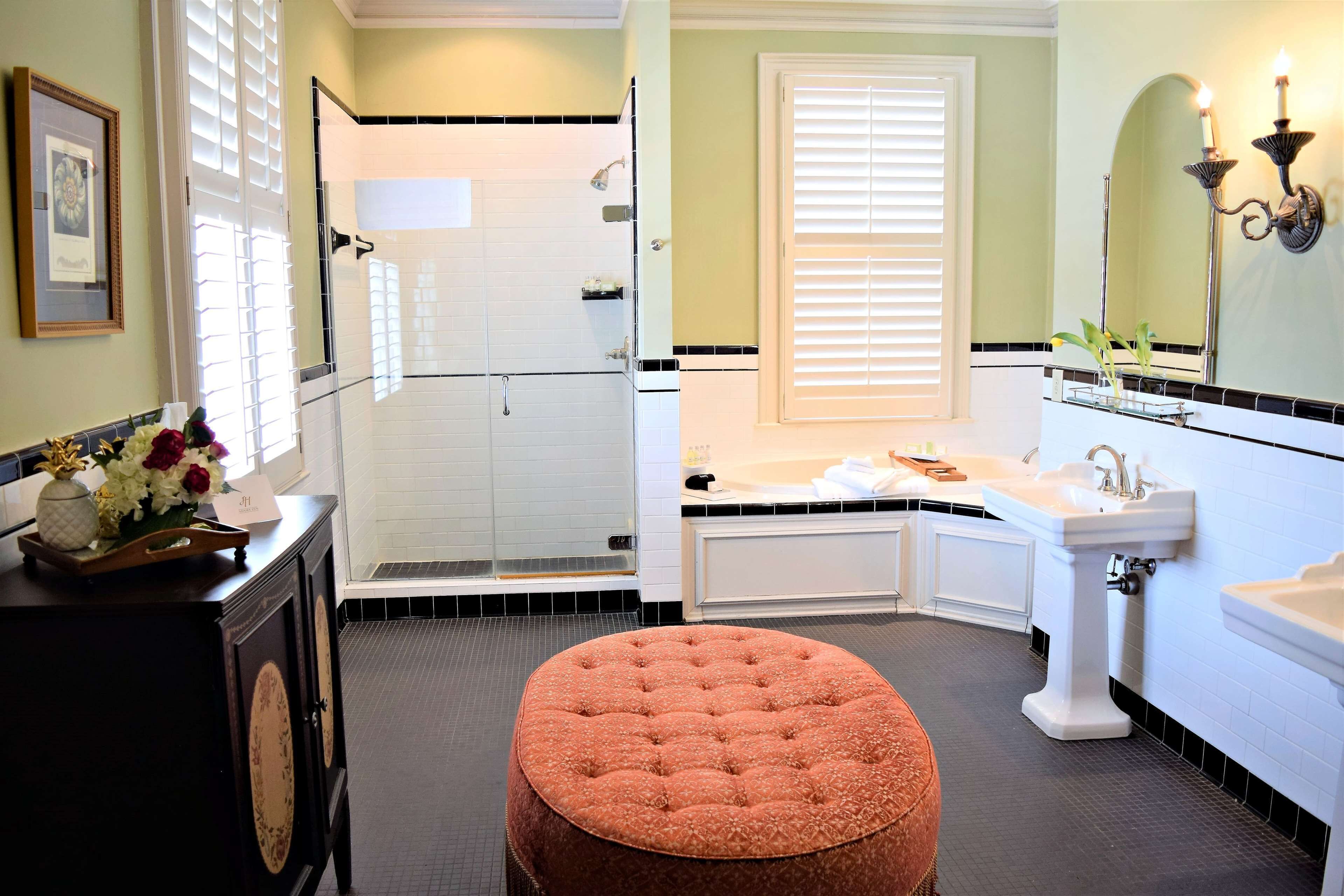 A bathroom with a shower, a bathtub, a sink, and a toilet. There is a vanity with a mirror and a towel rack.